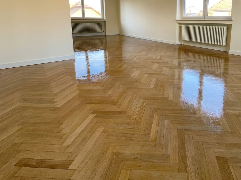Pièce vide avec parquet en bois massif, motif chevron, finition vernis brillant haute brillance