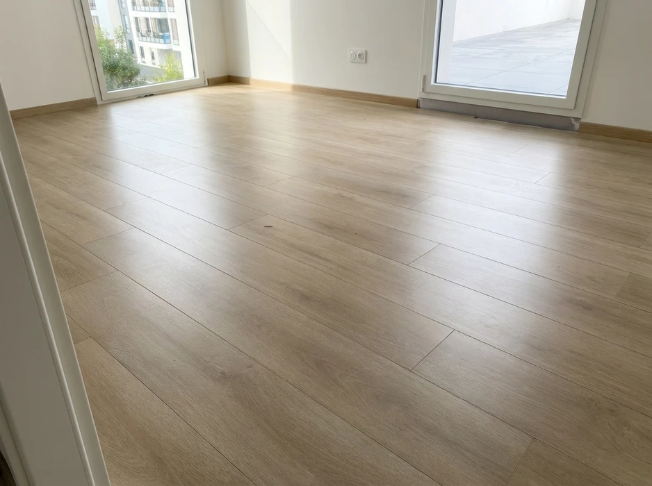 Pièce vide lumineuse avec sol en parquet stratifié imitation chêne blanchi, pose en biais