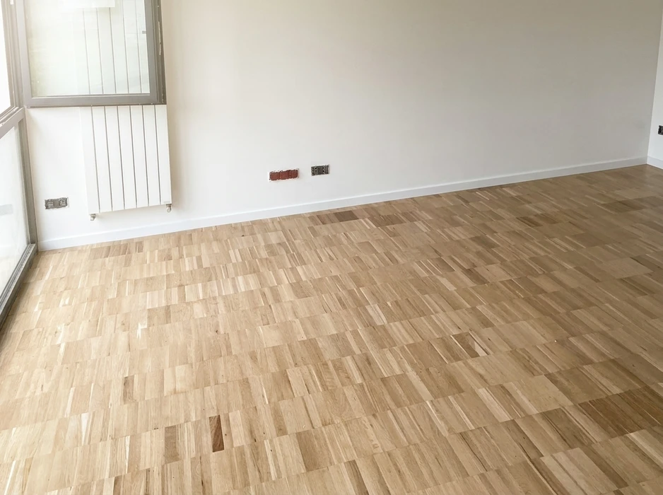 Pièce vide avec parquet en chêne massif, motif brique décalée, finition vitrifiée mate, teinte naturelle claire