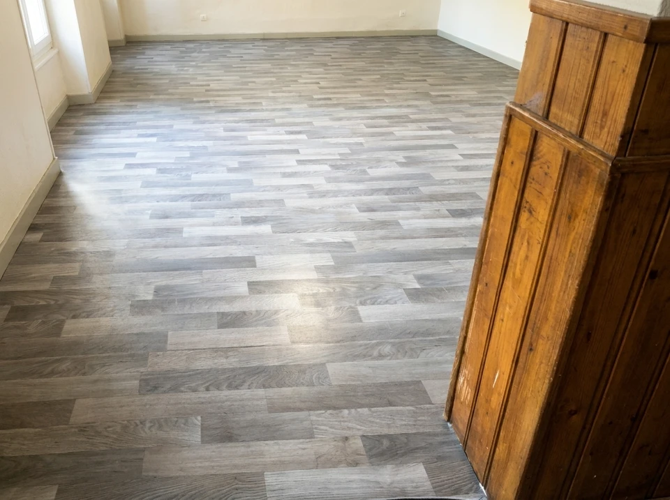 Pièce vide aux murs bleu pétrole, parquet en lames de chêne massif récemment vitrifié, finition brillante haute luisance encore fraîche
