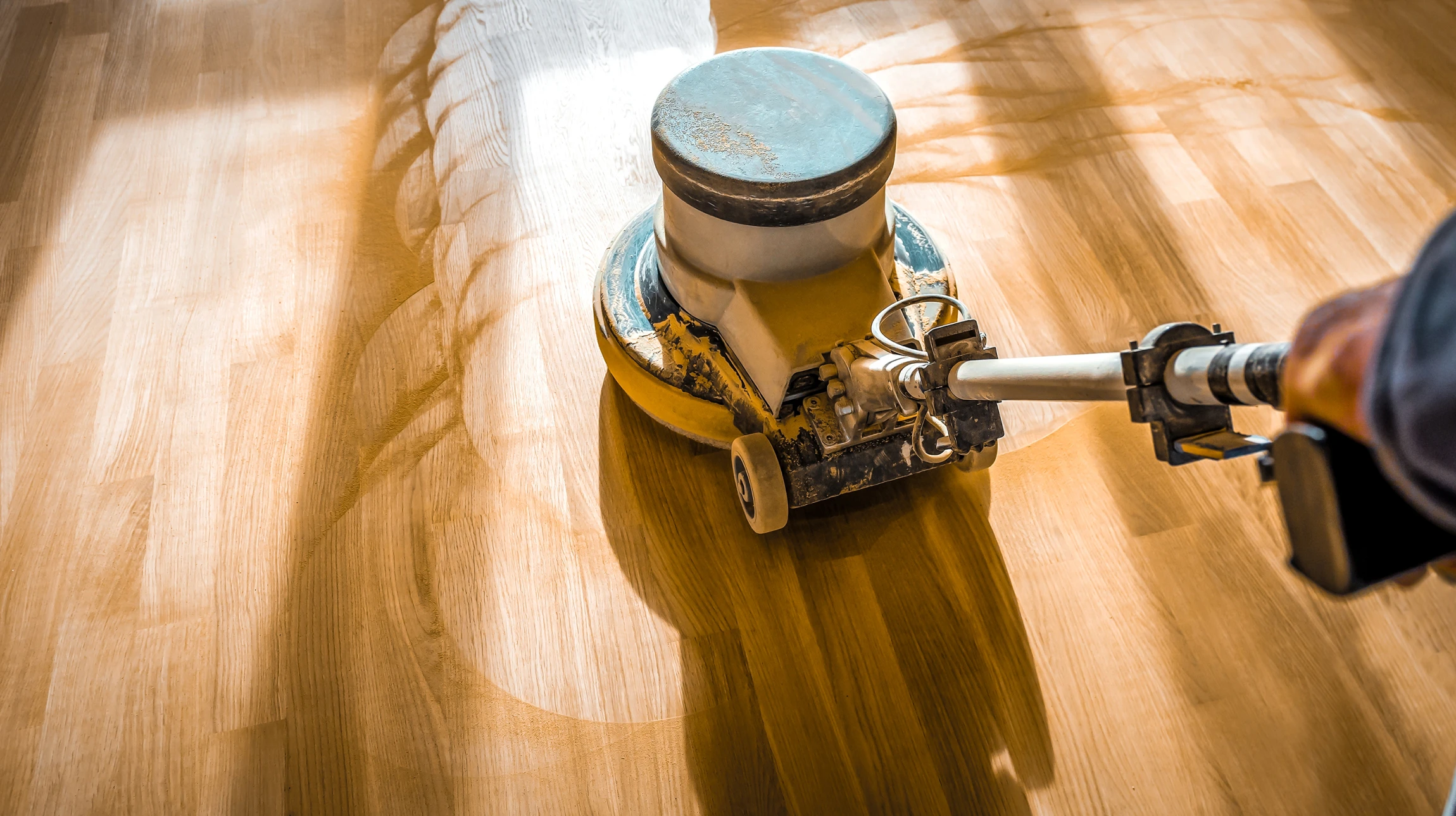 Un artisan à genoux installe un revêtement de sol en lames de parquet flottant dans un intérieur résidentiel