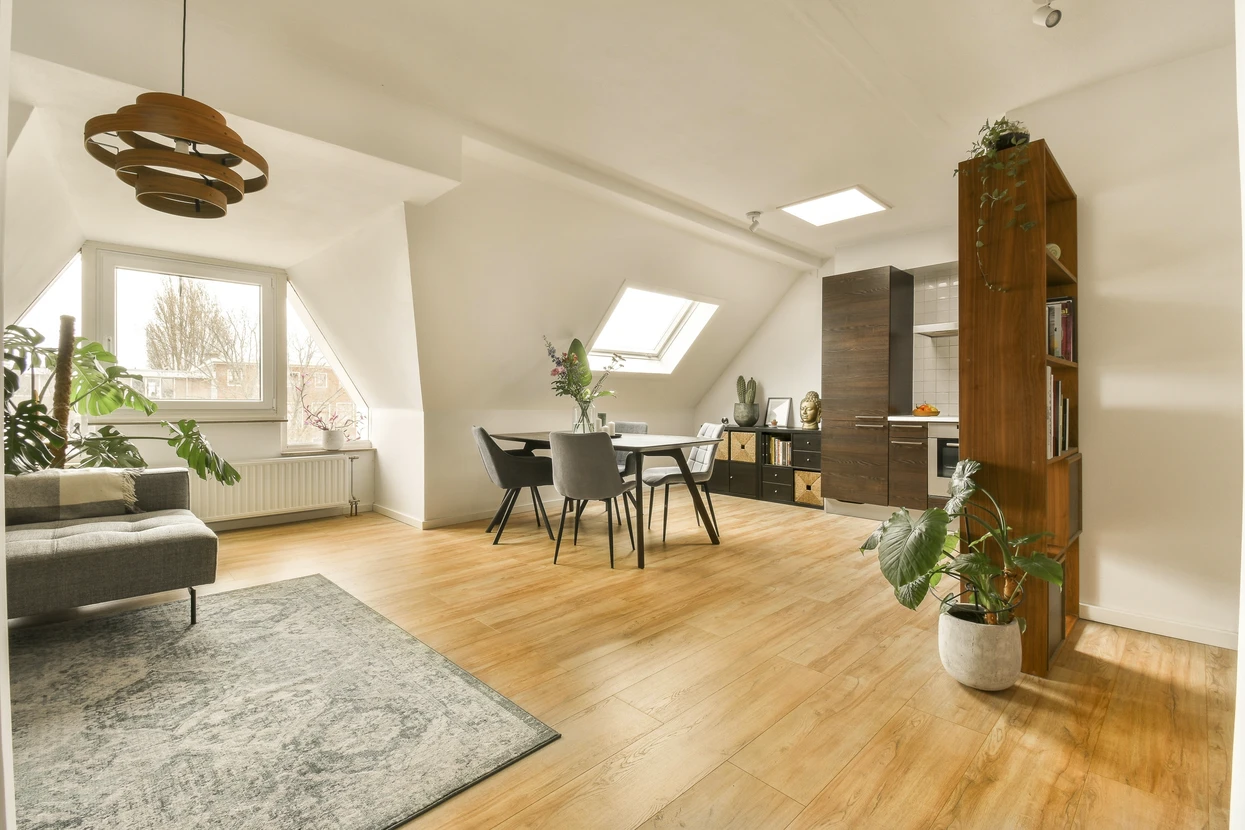 Salon meublé d'une maison à la décoration ornée, parquet de chêne français et portes menant à une terrasse allongée