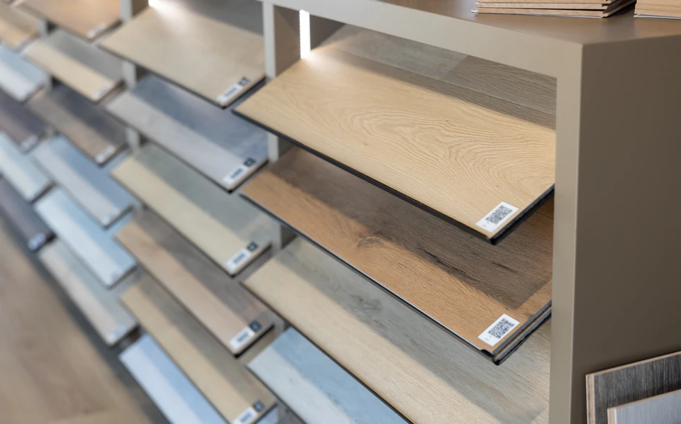 Empilement de planches de bois sciées stockées en extérieur, présentant différentes essences et nuances naturelles allant du brun clair au rougeâtre